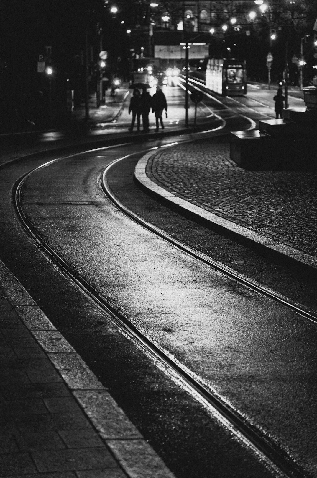 European city street at night with wet pavement and street lights