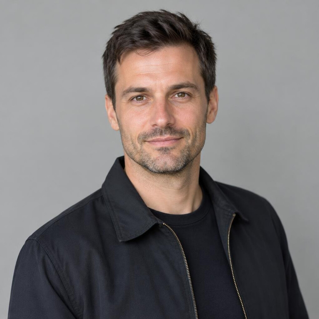Portrait of a man with short dark hair in a dark jacket